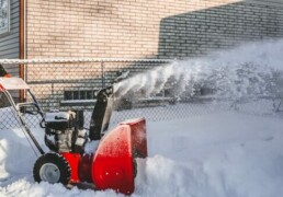 Image of a red snow blower being used by a snow removal service.