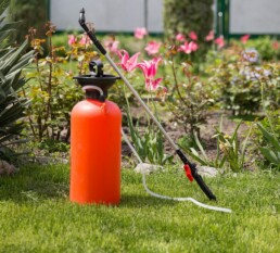 Liquid fertilizer spreader sitting on someone's lawn.